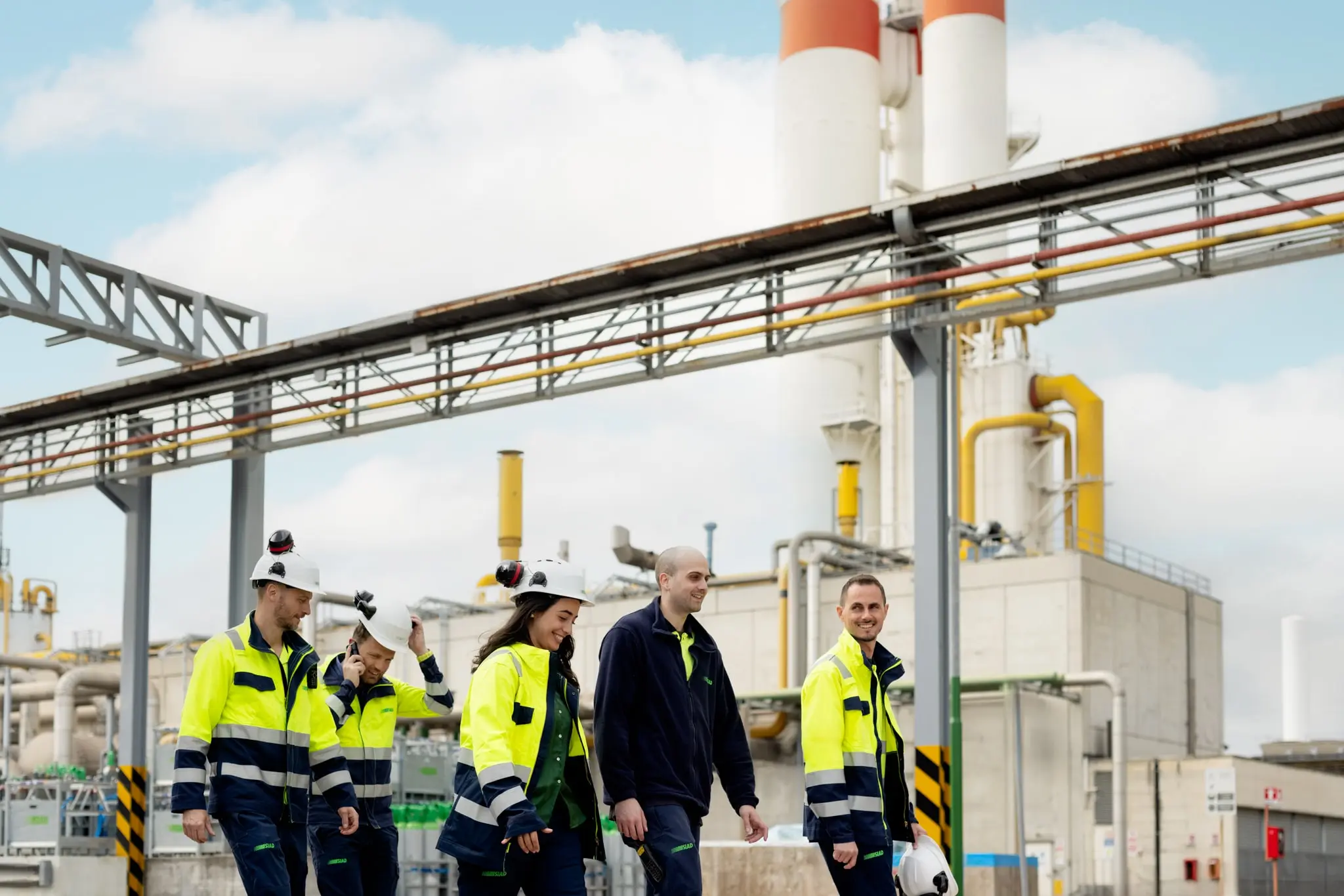 People walking through the SIAD Osio Sopra plant, highlighting teamwork and industrial operations.