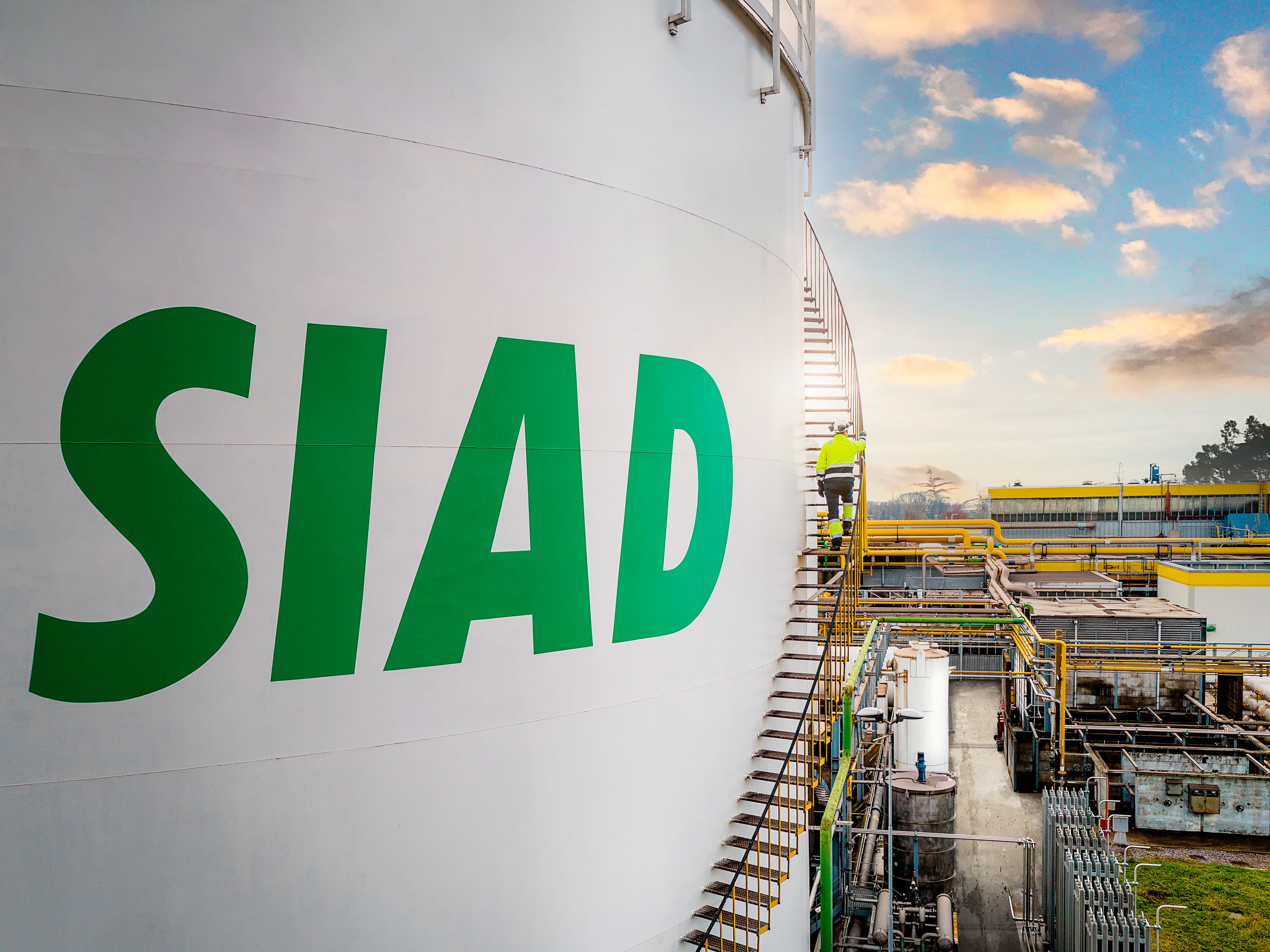 SIAD employee walking up the stairs of a nitrogen cryogenic tank at an industrial facility.