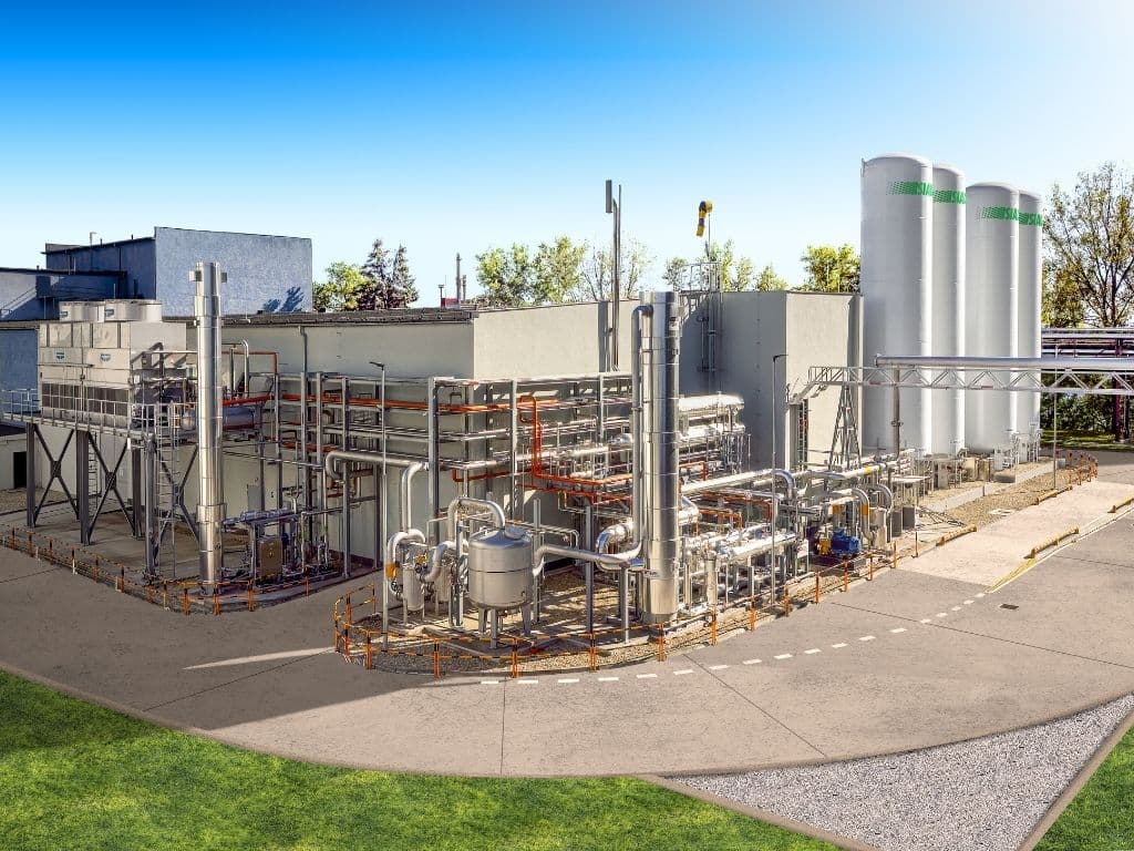 Industrial facility with stainless steel pipelines, processing units, and vertical storage tanks