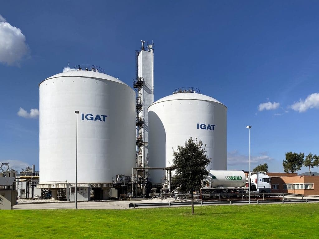 Large IGAT storage tanks at an industrial facility with SIAD tanker truck in foreground