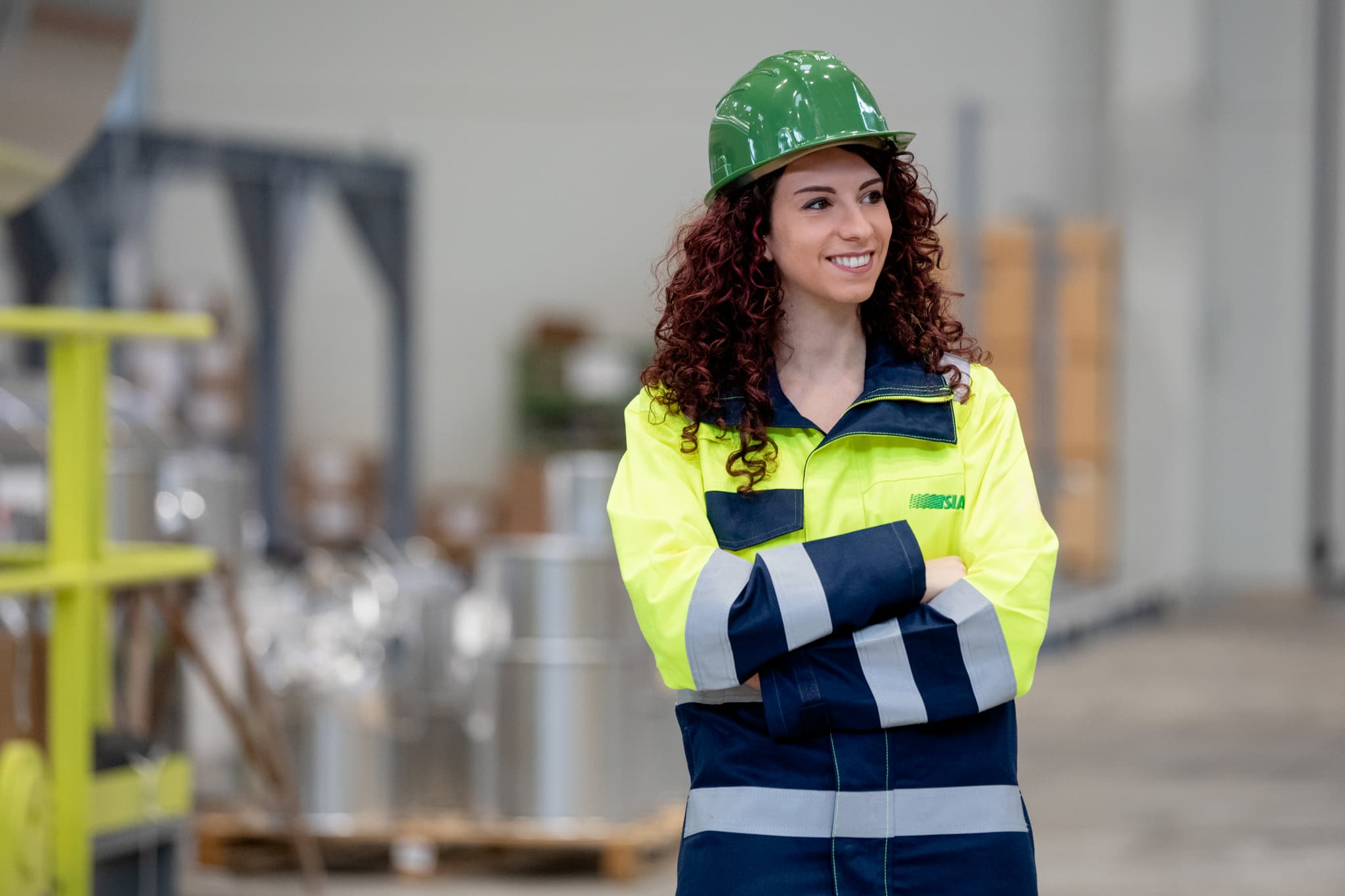 SIAD woman smiling with safety helmet inside Tecno Project Industriale facility