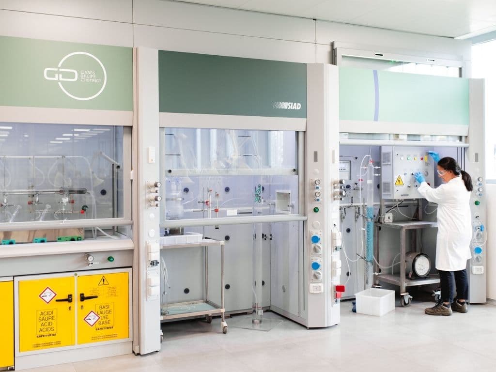 Modern lab featuring fume cupboards, chemical safety signage, and precision instruments