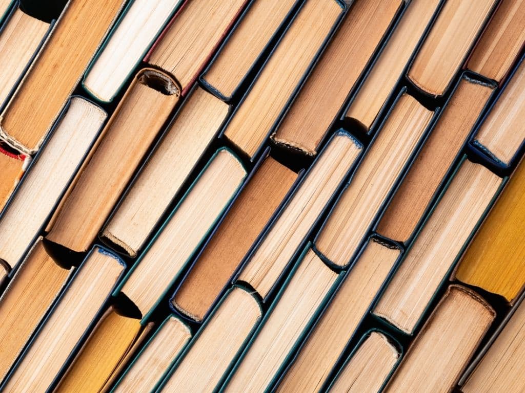 Stack of hardcover books arranged vertically showing aged spines and pages